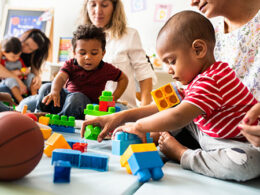 photo of chldren playing with blocks on floor