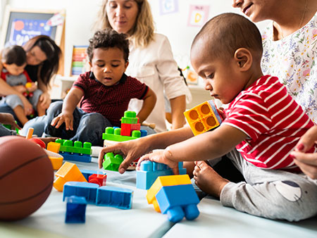 photo of chldren playing with blocks on floor